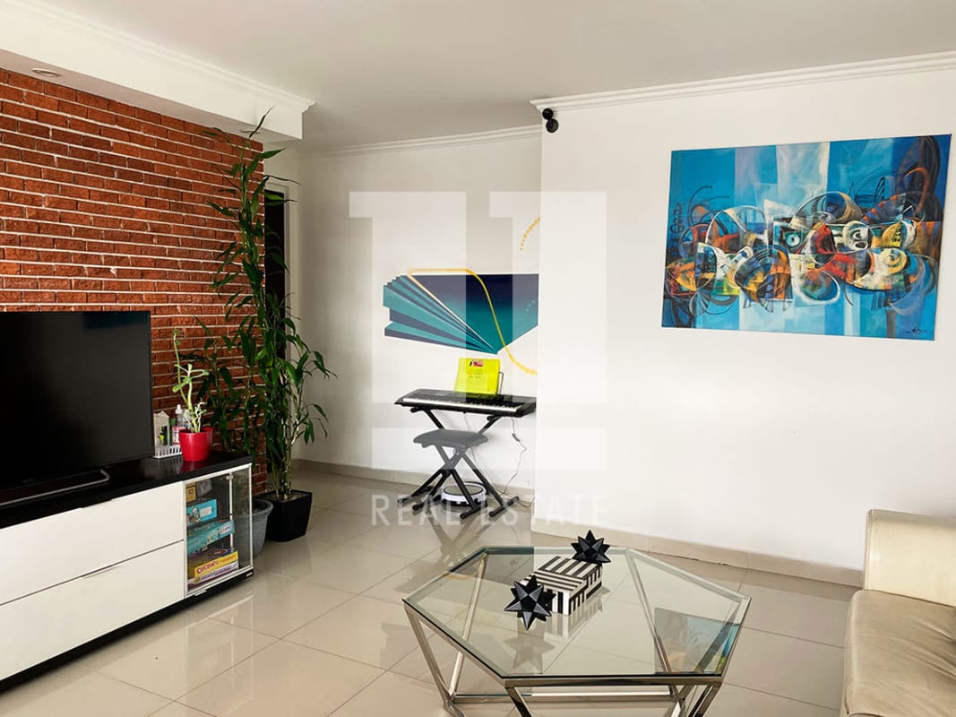 Living room with exposed red brick accent wall and modern decor in PH Sky Level Panama City