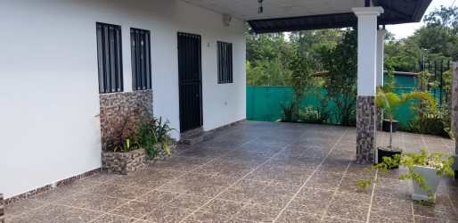 Outdoor patio with stone accent walls, potted plants, iron window bars in Barrio Linton