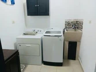 Laundry room with washer, gas dryer, and sink inside rental house Barrio Linton Las Lomas