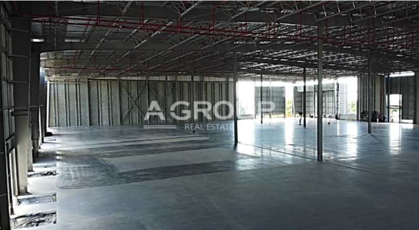 Large open warehouse area featuring polished concrete floors and steel roofing structure