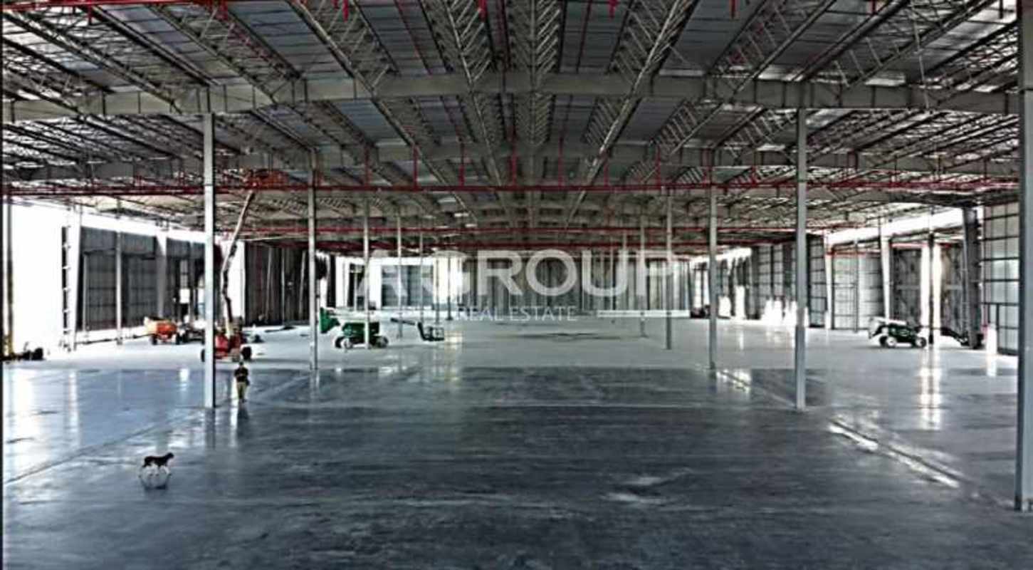 Wide industrial warehouse in logistics park with overhead sprinkler system and concrete floor