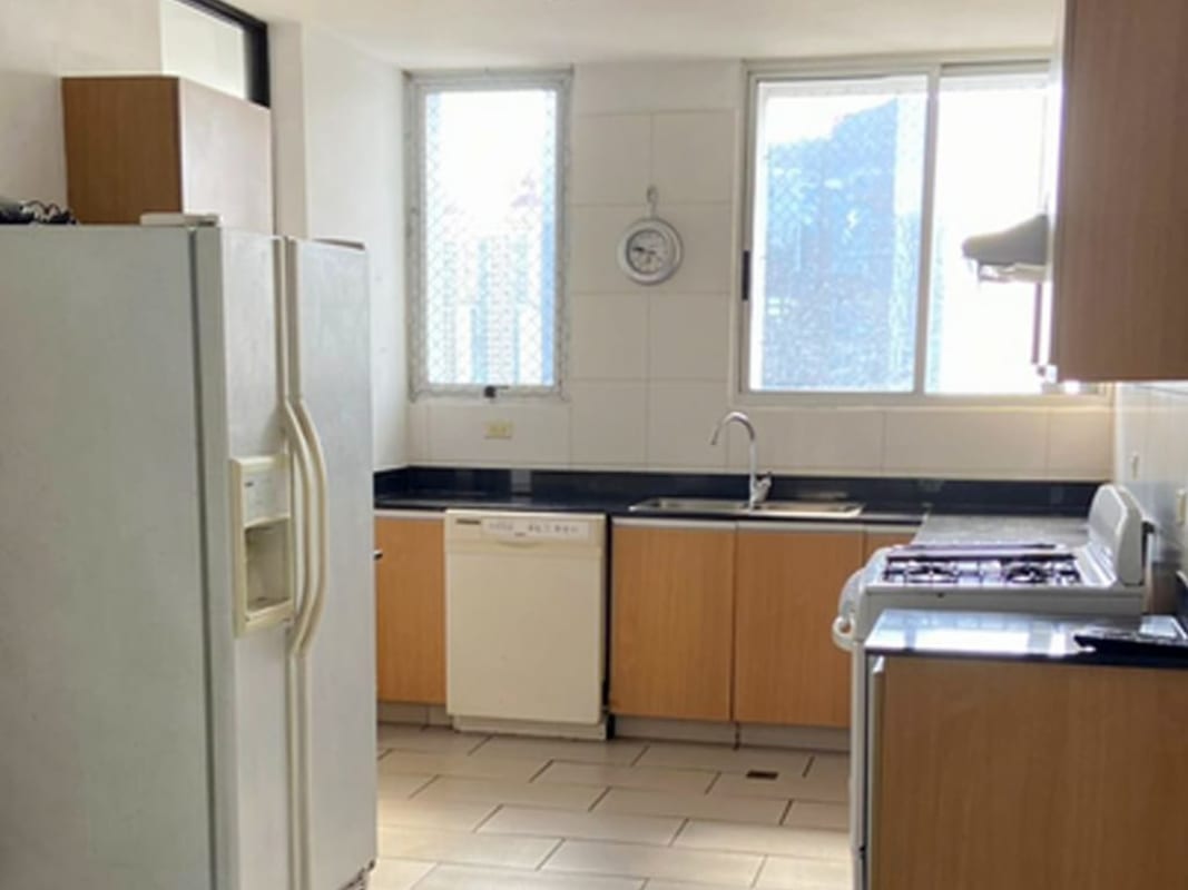 Contemporary kitchen with appliances, black countertops, wooden cabinets at PH Pacific Coast Panama City