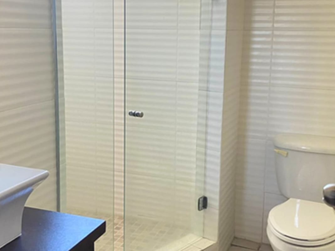 Bathroom with glass shower enclosure modern sink tile finishes PH Pacific Coast Panama City