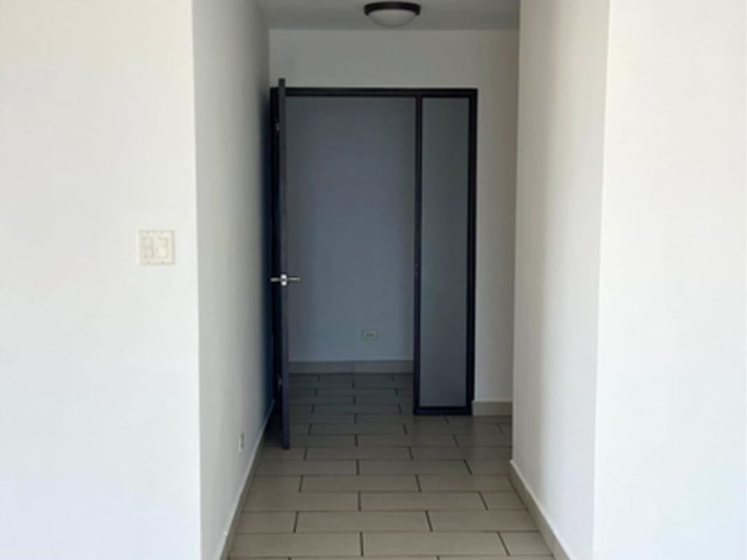 Minimalist hallway white walls black-trimmed glass door PH Pacific Coast Panama