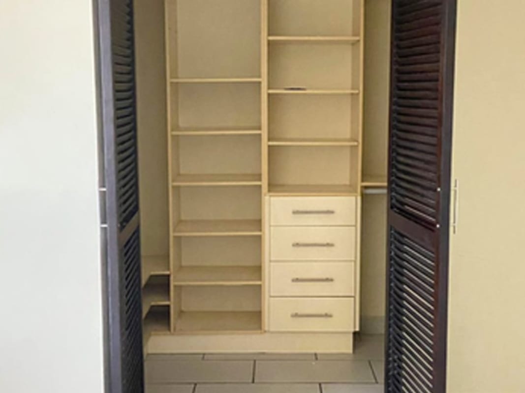 Closet with shelves drawers louvered doors in modern condo PH Pacific Coast Panama