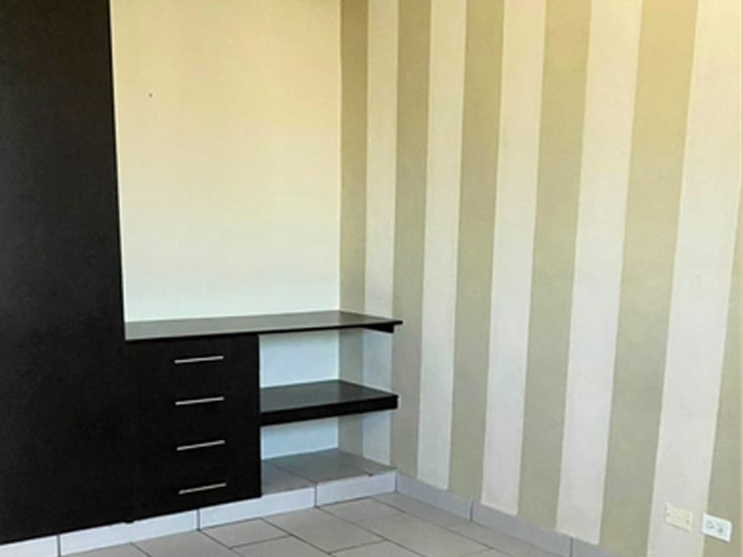 Bedroom featuring striped accent wall built-in storage tile floors PH Pacific Coast San Francisco Panama