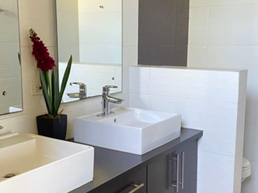 Bathroom with two sinks modern fixtures large mirror PH Pacific Coast San Francisco Panama