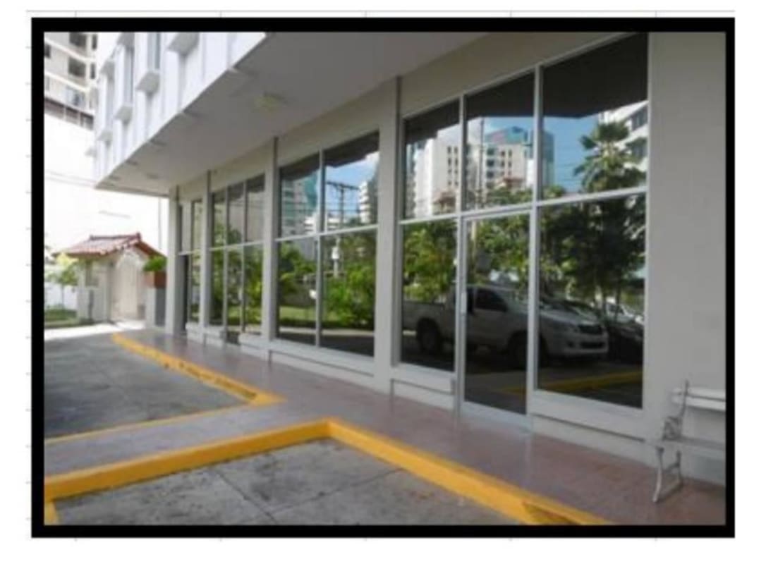 Glass commercial building with city reflections and sidewalk Marbella Panama