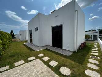 Minimalist flat roof house with large windows and landscaped garden at Ibiza Residences Coclé Panama