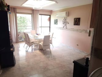Mid-rise apartment building with balconies, surrounded by palm trees in Espinar Colón Panama