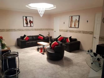 Bright dining area with large windows, white chairs, glass table in Espinar Colón Panama apartment