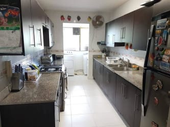 Kitchen with dark wood cabinets, granite countertop, appliances in Espinar Colón Panama apartment