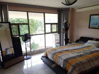 Bedroom with natural light, large window, striped bedding in Espinar Colón Panama