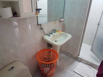 Bathroom with glass shower, large mirror and orange laundry basket in Espinar Colón Panama