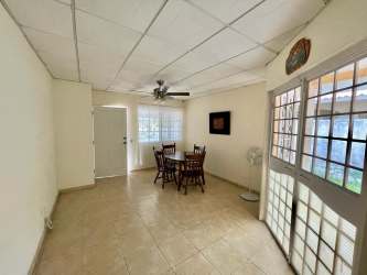 Kitchen with tiled counters, window and storage in family house Chitré Panama