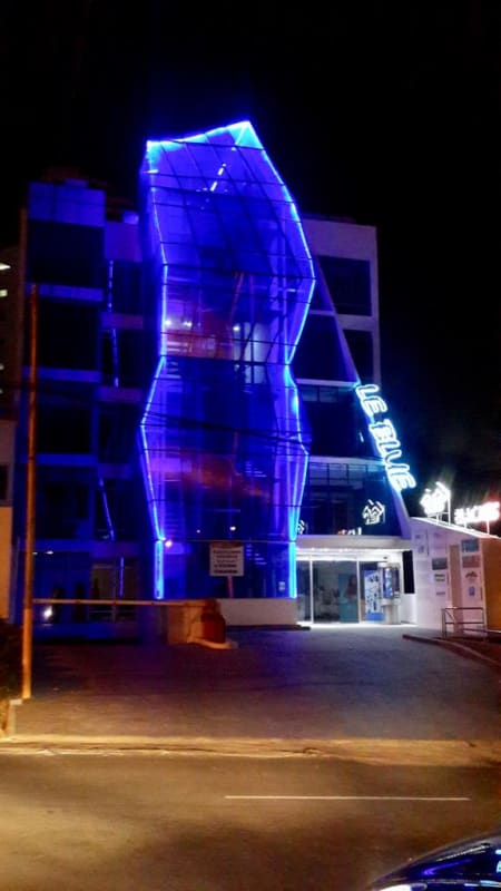 Curved glass facade and blue LED lights illuminate PH LeBlue at night in Panama City