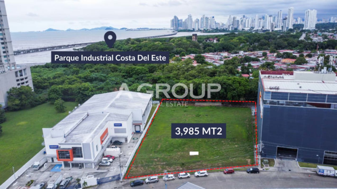 Wide vacant industrial lot bordered by storage warehouses at Parque Industrial Costa del Este