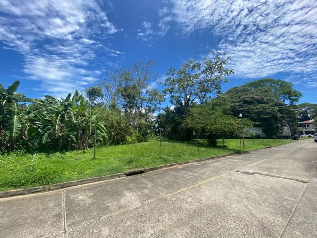 Vacant residential lot with lush vegetation and partial house view in Diablo Ancón Panama