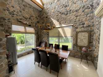 Spacious living room with cathedral ceiling and exposed wooden beams in luxury beach house
