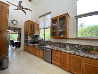 Rustic dining area with vaulted ceiling, stone wall, panoramic windows in Punta Barco beach house