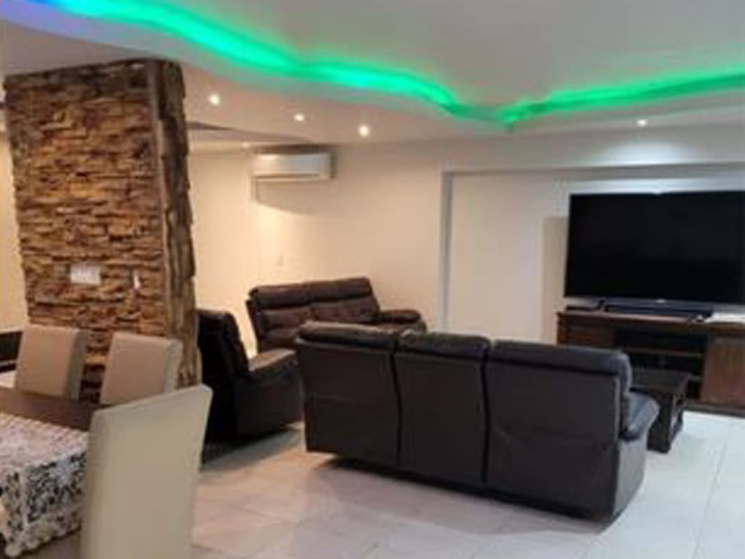 Spacious living dining area with stone wall, LED lighting, flat screen TV, in PH Oceania Plaza Edison Panama City