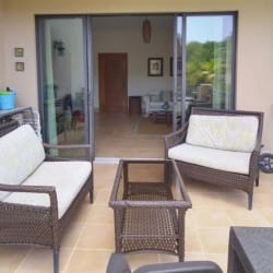 Covered terrace with outdoor seating facing golf green in Buenaventura resort Río Hato Panama