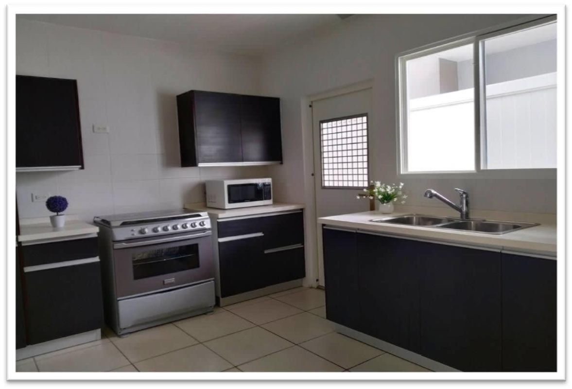 Modern minimalist kitchen with dark cabinets large window PH Augusta Brisas del Golf Panama