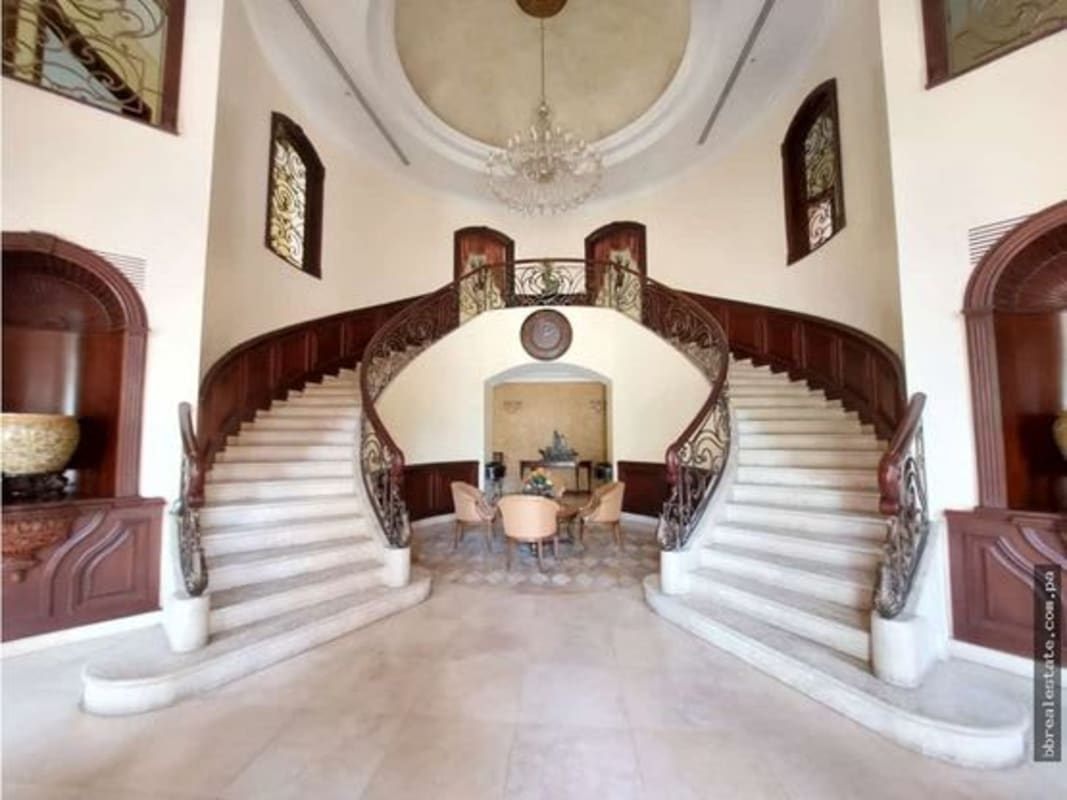 Elegant mansion foyer with twin grand staircases in Villa del Mar Panama City