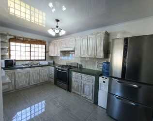 Mountain home kitchen with stainless appliances, wooden cabinets, tile counters, large window in Alto Boquete