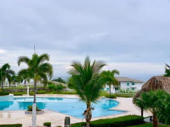 Modern furnished living room with blue accent wall, ocean view balcony in Beachfront Condo Bijao Panama