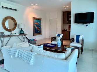 Open concept dining and living space white sofas tropical decor ocean view balcony Bijao Panama
