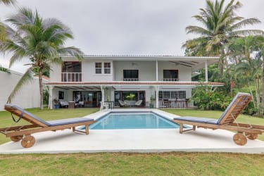 Spacious living room with calicanto stone wall and large windows in ocean view villa Costa Esmeralda