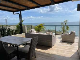 Rooftop terrace with illuminated jacuzzi and ocean backdrop night view Punta Caelo