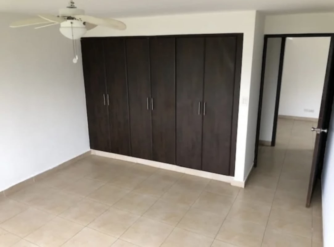 Empty bedroom with beige tile floors, built-in wardrobe, ceiling fan Los Angeles Panama City