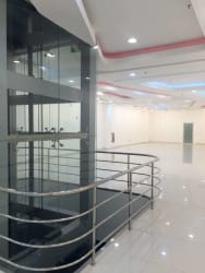 Lobby of commercial building with glass elevator and stylish lighting inside Zona Libre Colón Panama