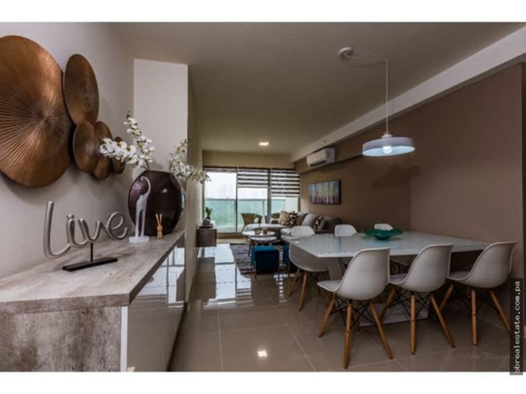 Modern kitchen with granite counters, dark cabinetry and backsplash inside apartment at PH Residencias del Sol Carrasquilla Panama