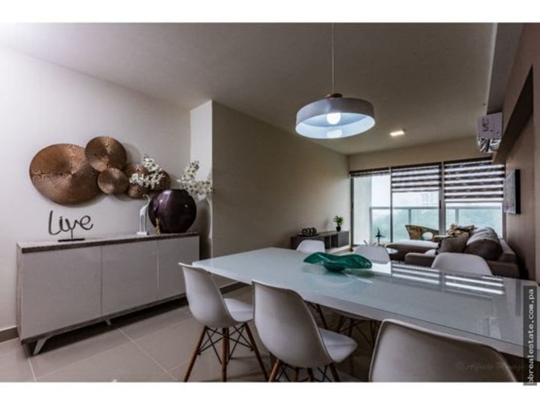 Open plan living and dining room with balcony and city views in PH Residencias del Sol Carrasquilla Panama City
