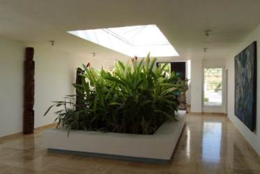 Bright hallway with marble floors, indoor planter garden, skylight in beachfront villa San Carlos Panama