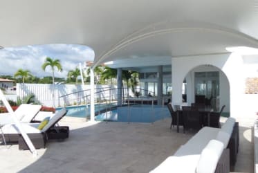 Shaded patio with pool, lounge chairs, tropical landscaping at luxury villa Vistamar San Carlos Panama
