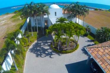 Mediterranean domed white mansion, palm trees, driveway, ocean backdrop in Vistamar resort San Carlos