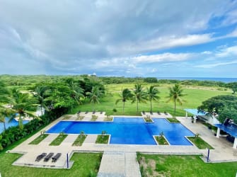 View of the gigantic saltwater lagoon pool with palm trees at Playa Blanca Resort Panama