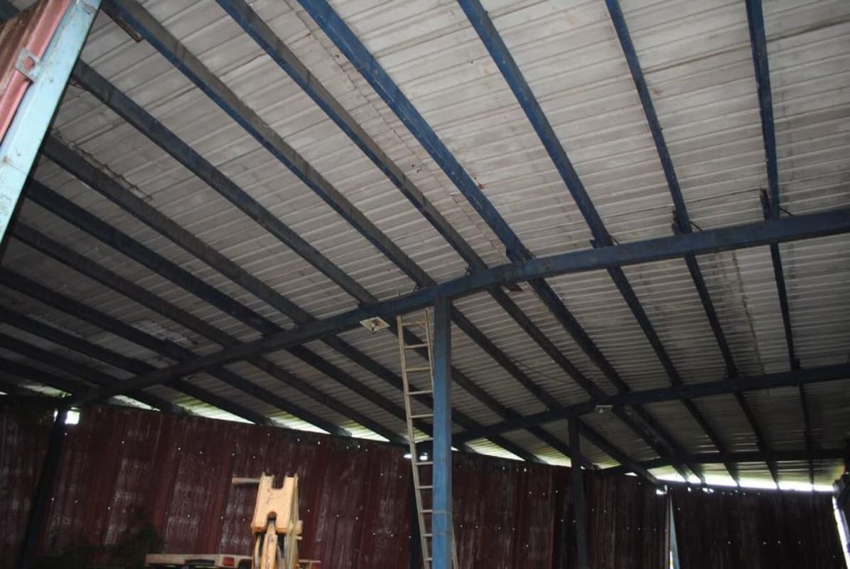 Interior warehouse showing steel support beams and metal roof in Panama for sale