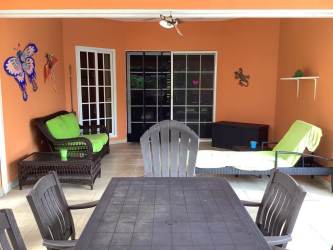 Covered patio with dining set hammock palm trees backyard of beach house in Portobelo Panama