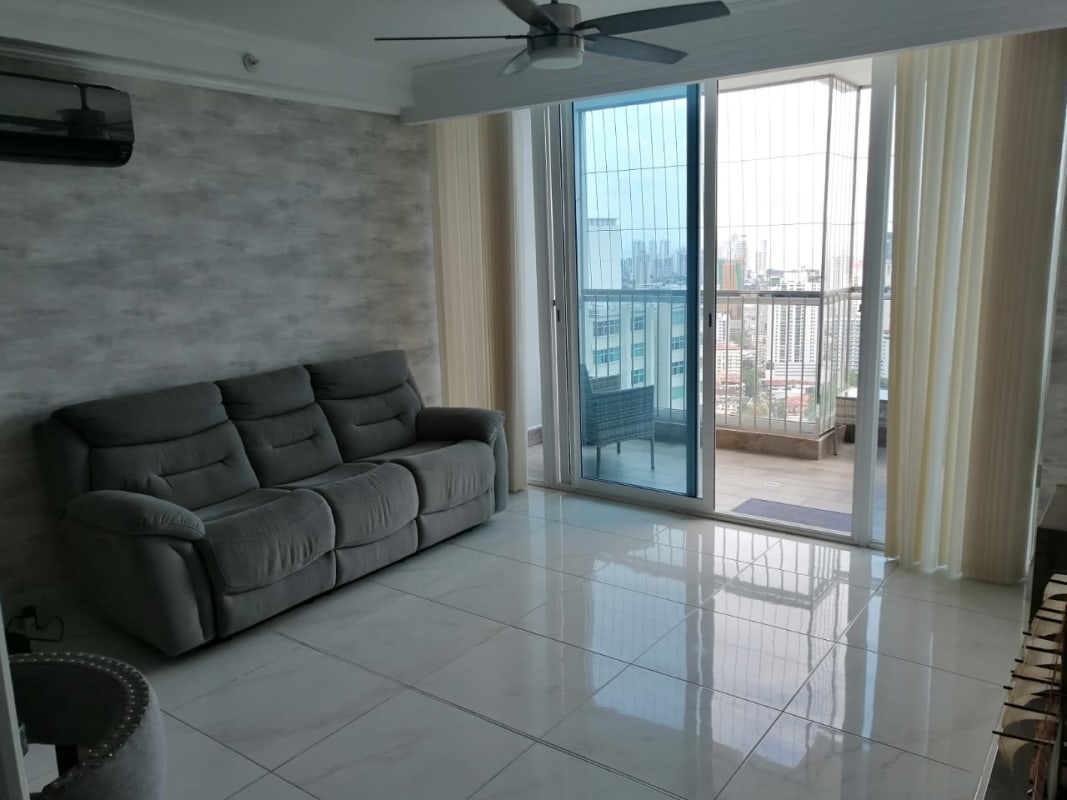 Living and dining area leading to balcony with skyline panorama in PH Pacific Park Edison Park