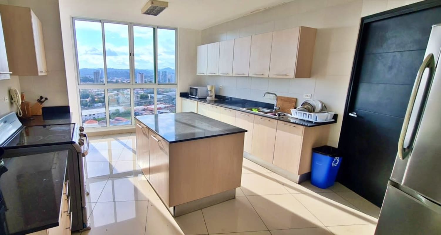 Kitchen with island, granite countertops, stainless appliances and panoramic window at PH Highland View Panama City