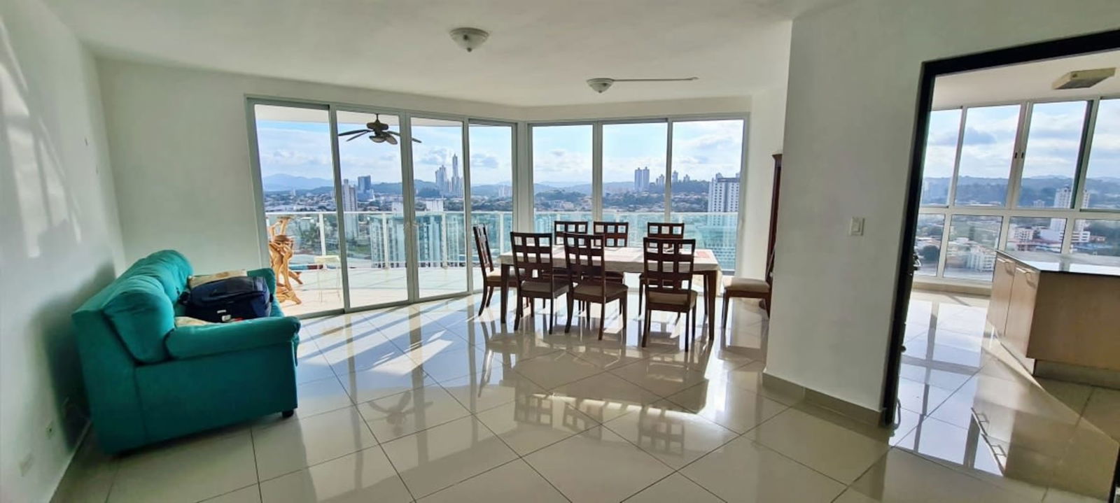 Open plan living and dining room with large windows and skyline views PH Highland View Panama