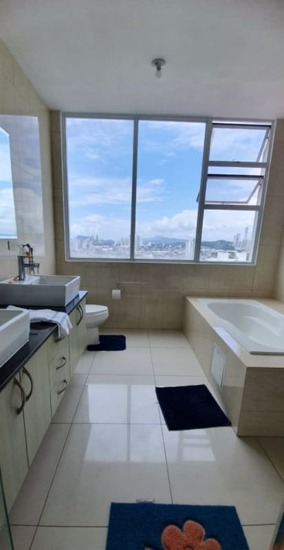 Bathroom with dual sinks, large mirror and panoramic city view at PH Highland View Panama