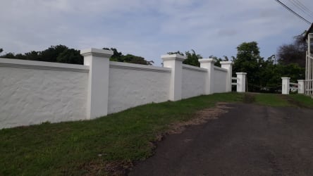 Secured boundary fence double steel rail concrete columns beach land Punta Barco