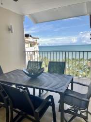 Bedroom with white and aqua coastal décor facing ocean at Puntarena Buenaventura luxury condo Panama
