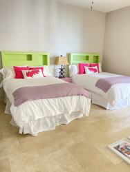 Twin beds with coastal theme and light flooring at Puntarena Buenaventura Panama